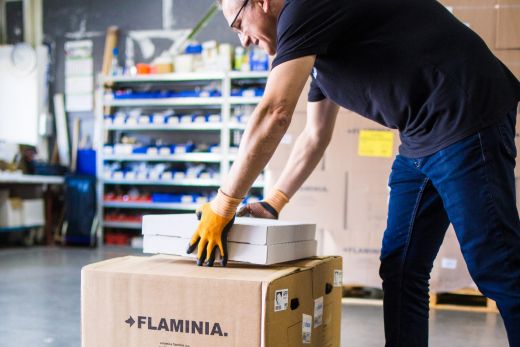 Ein Tag bei FLAMINIA Deutschland: 19/24 – Die benötigten Kartonagen und Verpackungen werden auf Pressholzpaltetten gestapelt. Hierbei wird natürlich besonders darauf geachtet, dass die schweren Produkte direkt auf der Palette lagern, während die leichteren darauf gestapelt werden.